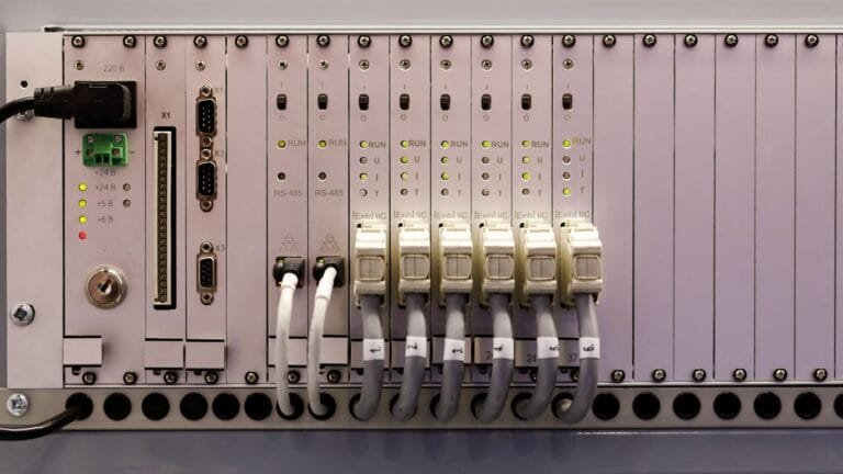 Programmable Logic Controller (PLC) mounted on a control panel, displaying real-time process data and input/output connections.